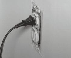 Loose electrical outlet showing electrical plug falling out.